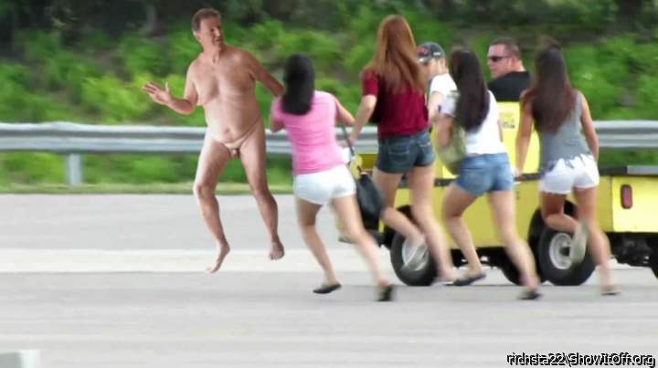 Security trying to catch streaker as women race to take photos.